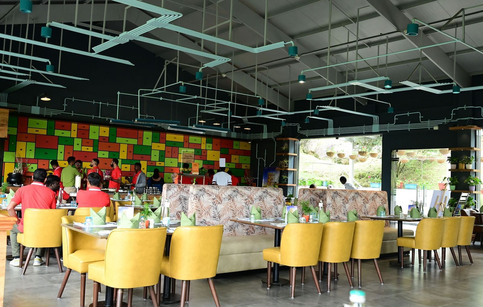 An image of a restaurant with seating arrangement, cutlery, and decorative items - GReaT trails Kodaikanal by GRT Hotels