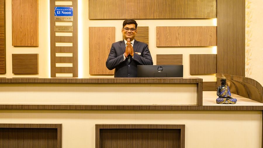 A man greeting guests at the reception area of Biznotel by Pride, Deoghar