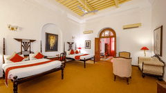 An overview of the Maharaja Bhupinder Singh room with twin double beds, sofas and an ac wall mounted - The Baradari palace
