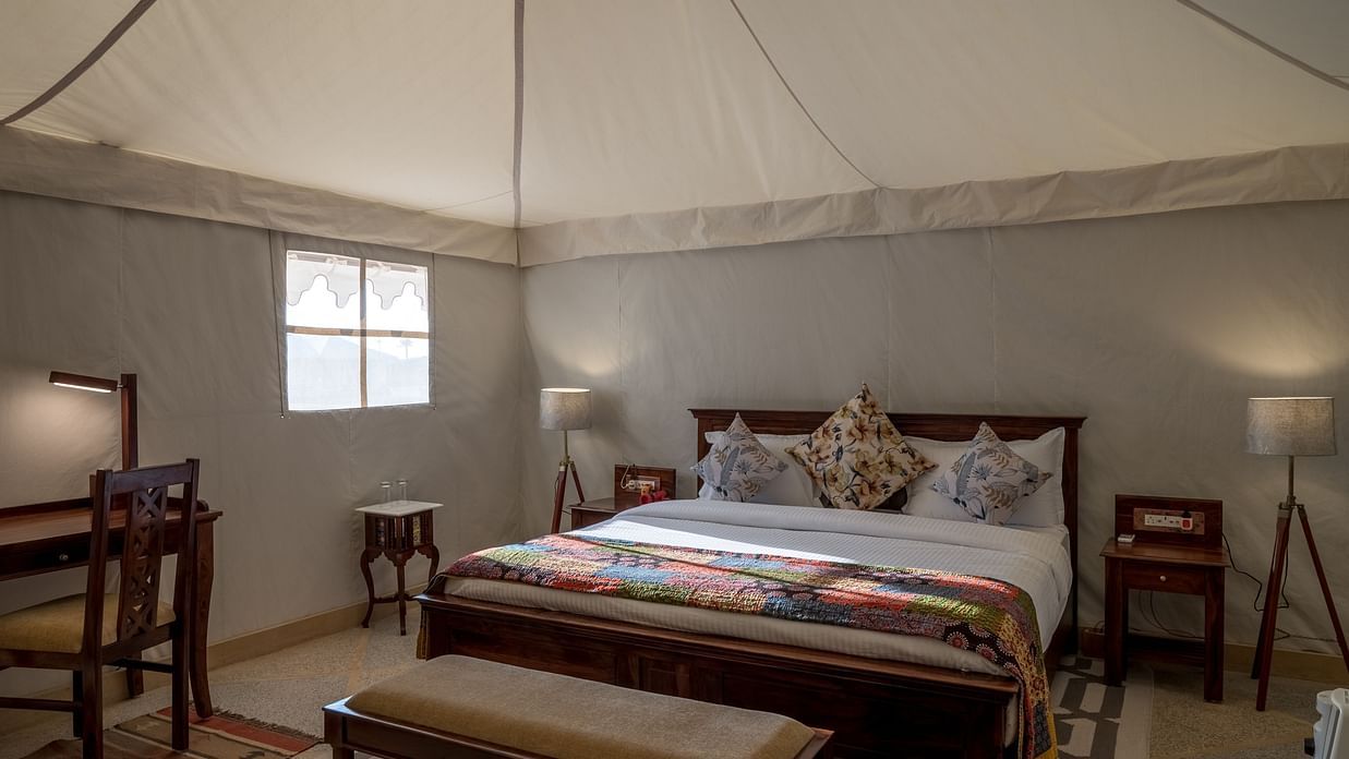 The interiors of the Premium camp offers a comfy bed, work desk and other amenities - Karwaan Jaisalmer