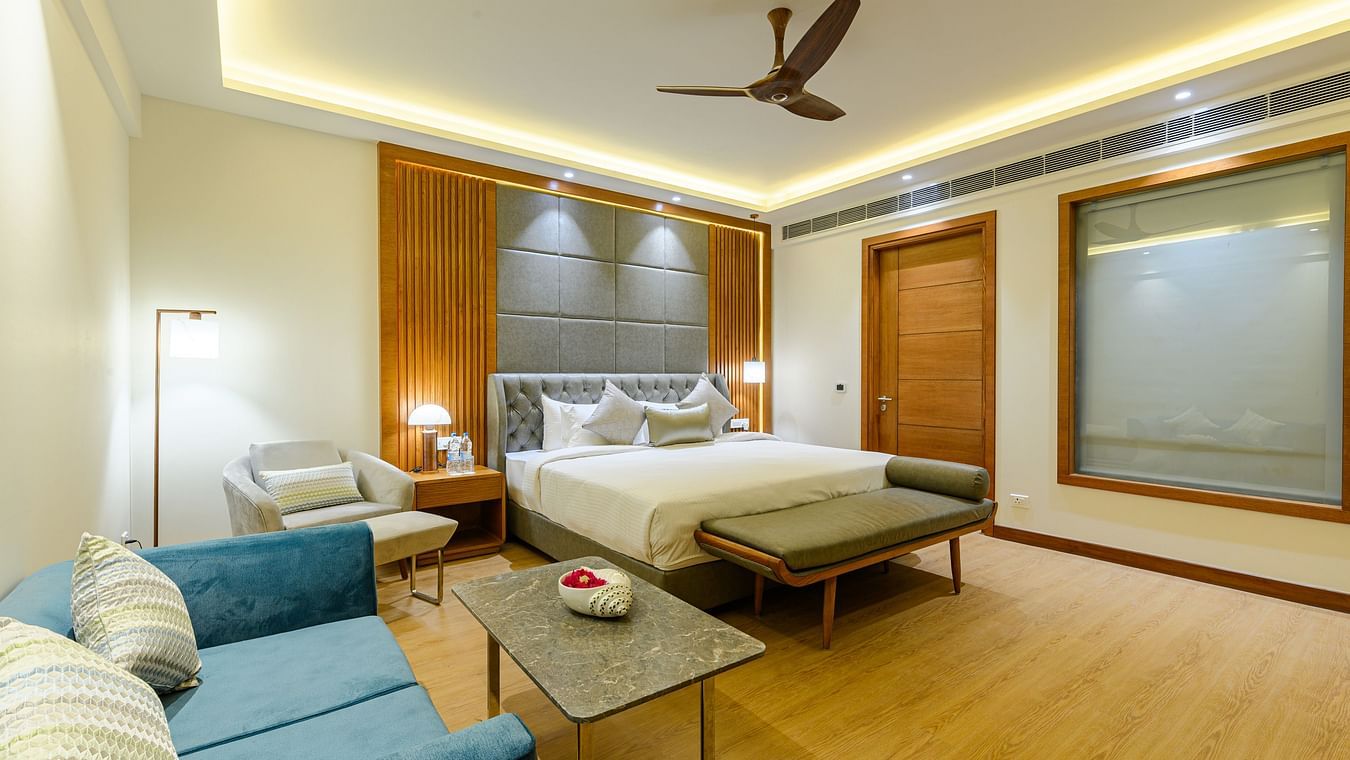 Interiors of one of the bedrooms at our presidential suite in Pushkar featuring a bed, a blue sofa and other furniture 57