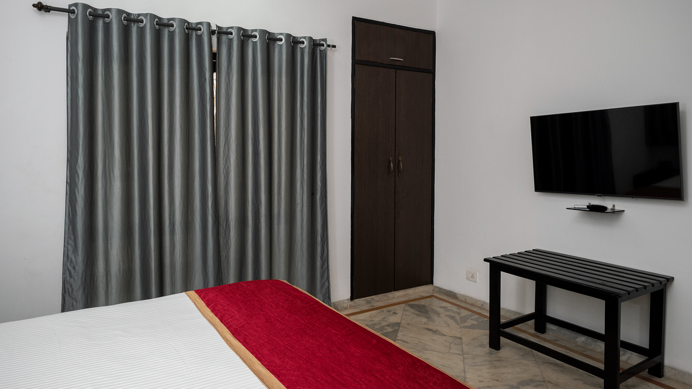 The bedroom with an LED TV, table and off white walls