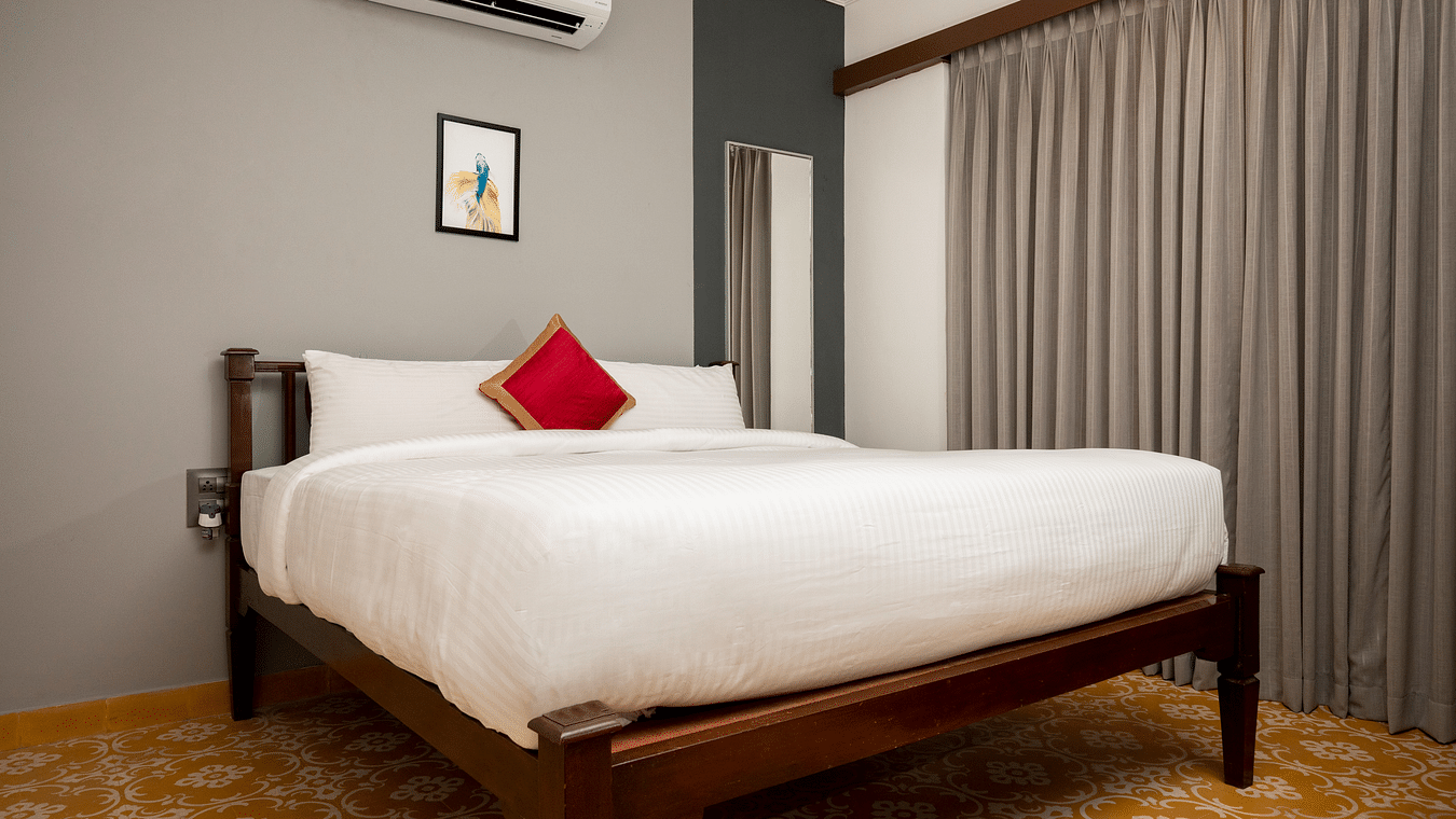A large bed surrounded by grey walls