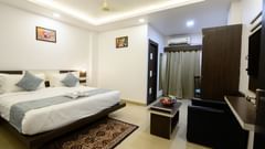 Side view of the Superior King Room showcasing a cozy bed and stylish interior design at Biznotel by Pride, Deoghar