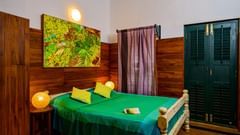 a luxury room with green bed sheets and night lamp on a stand 