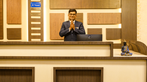 A man greeting guests at the reception area of Biznotel by Pride, Deoghar