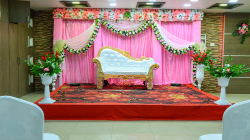 Tirkuta Hall stage featuring a long chair decorated with flowers at Biznotel by Pride, Deoghar