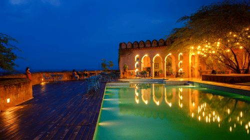 A vibrant blue pool with the resort at the background - Hill Fort Kesroli Alwar Rajasthan