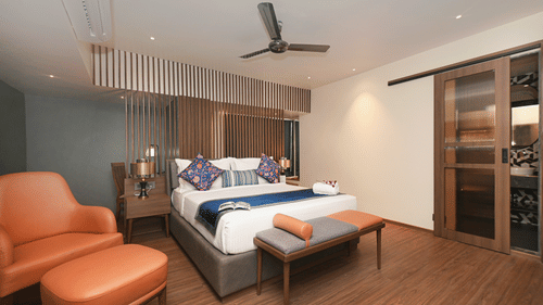 Studio Suite at Hotel Le Grande featuring a king size bed, warm wooden flooring, modern lighting, stylish seating, and a sliding glass door with a contemporary finish.