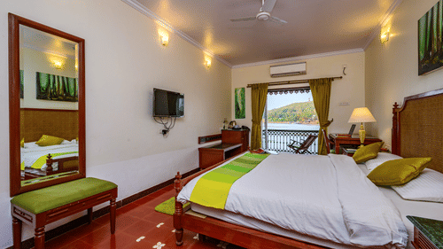 A double bed tv ac and balcony inside Cones - River View room at neemrana s three waters