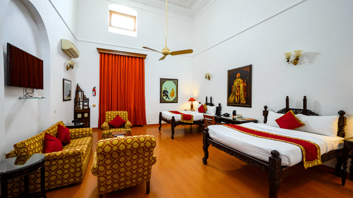 An overview of the Maharaja Rajinder Singh room with twin double beds in front of the sofas and a coffee table - The Baradari palace