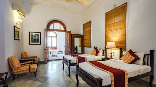 An overview of the Maharaja Yadavindra Singh room with a twin double bed, sofas on the side and entrance to the bathroom - The Baradari palace