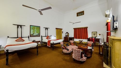 An overview of the Maharaja Narinder Singh room with twin double bed, chairs, coffee table in front of the tv - The Baradari palace