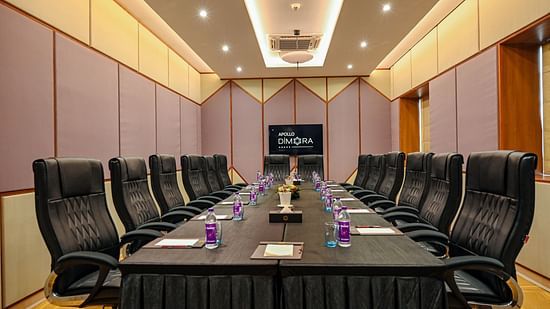 black coloured seats and a large table offered at the boardroom 