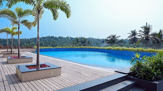 view of the swimming pool of Apollo Dimora hotel in Calicut