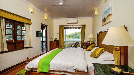 A double bed lamp on the marble side table and entrance to Olivia - River View room at neemrana s three waters