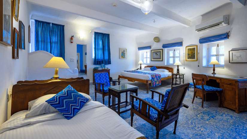 Hill Fort Kesroli 14th Century Alwar - interior view of the Shankar Mahal - Garden View room with a single bed, white lighting and blue decor