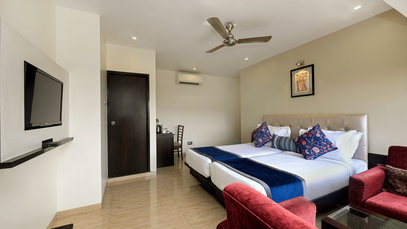 Premium room with cosy bed, a television, a ceiling fan, and tiled flooring at Hotel Le Grande - Mumbai International Airport.