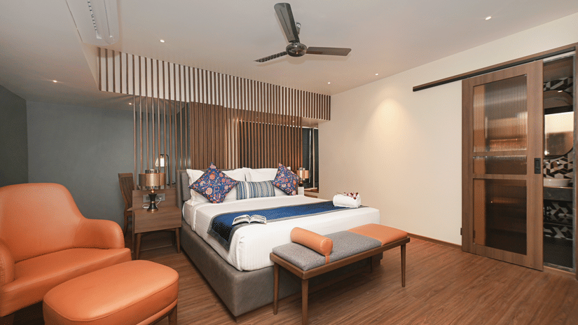 Studio Suite at Hotel Le Grande featuring a king size bed, warm wooden flooring, modern lighting, stylish seating, and a sliding glass door with a contemporary finish.
