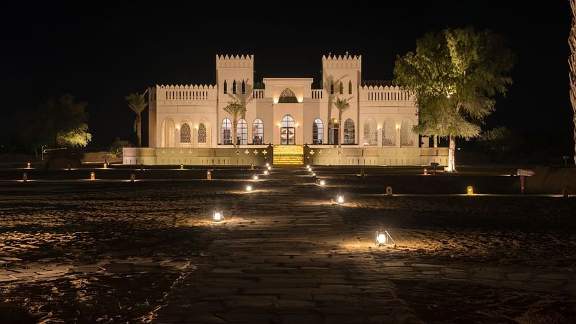 A beautiful view of the hotel facade at night surrounded by palm trees - Karwaan Jaisalmer