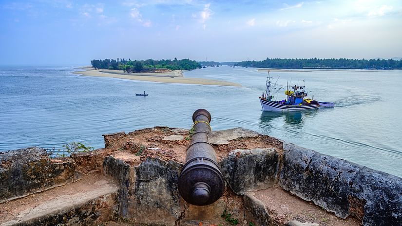 A cannon on top of the Betul Fort with a boat travelling on the beach