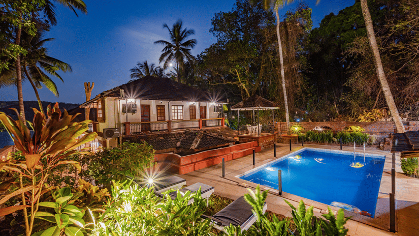 Swimming pool with lounge chairs and a building on the side at neemrana s three waters