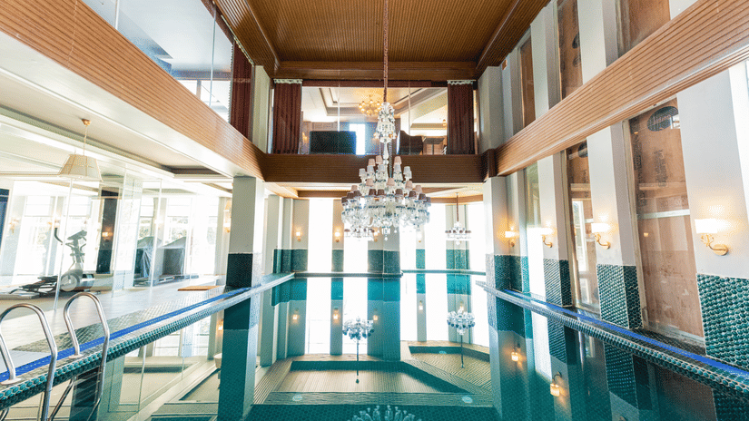 A swimming pool with a chandelier hanging above the pool - The Manor Luxury  Hotel, Shimla