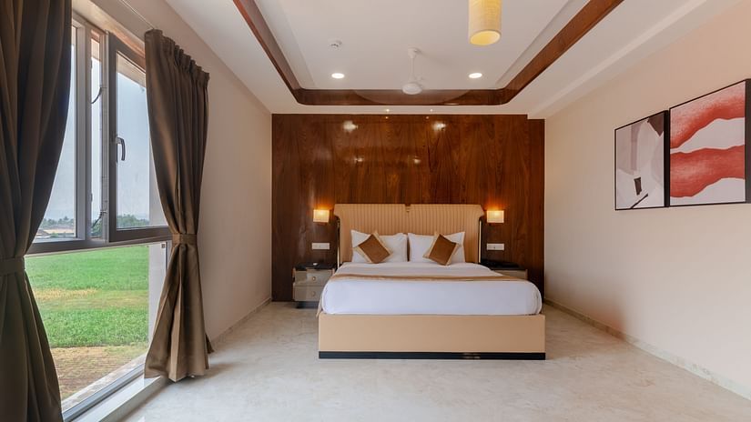 A double bed with side tables and lamps inside the Suite - VITS Satyajeet Karad