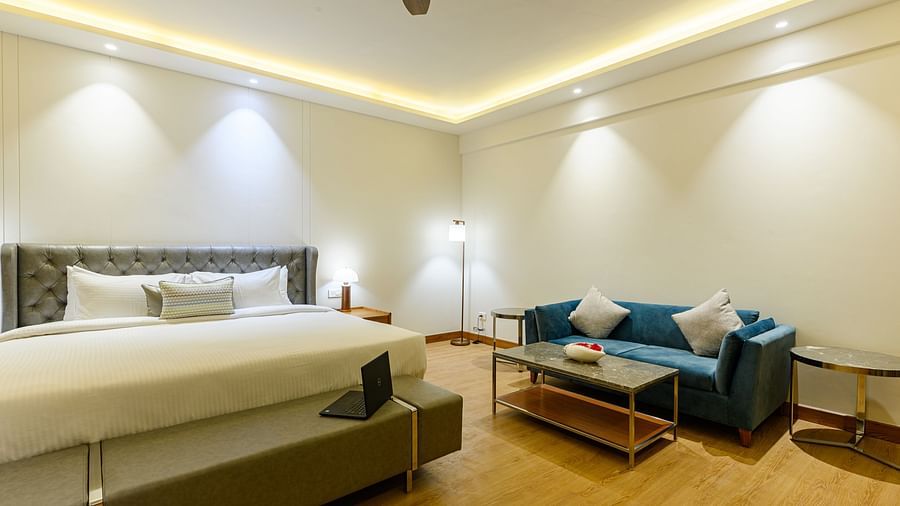 Interiors of one of the bedrooms at our presidential suite in Pushkar featuring a bed, a blue sofa and other furniture 57