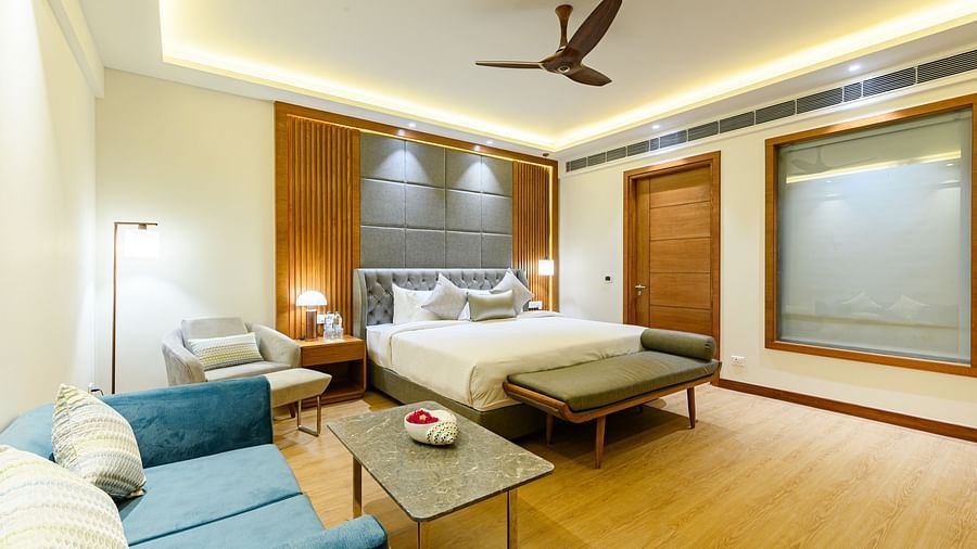 Interiors of one of the bedrooms at our presidential suite in Pushkar featuring a bed, a blue sofa and other furniture 5761