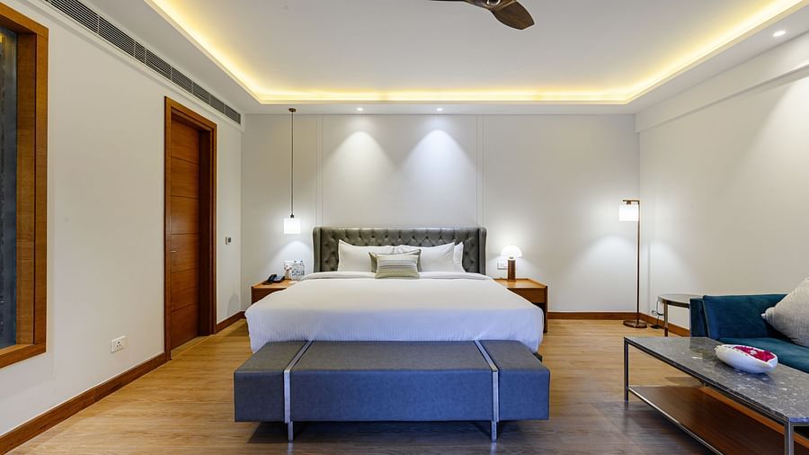 Interiors of one of the bedrooms at our presidential suite in Pushkar featuring a bed, a blue sofa and other furniture 5766