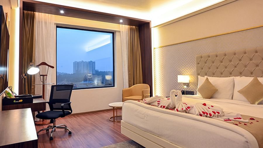 a king size bed and the work station at deluxe rooms in Calicut 2