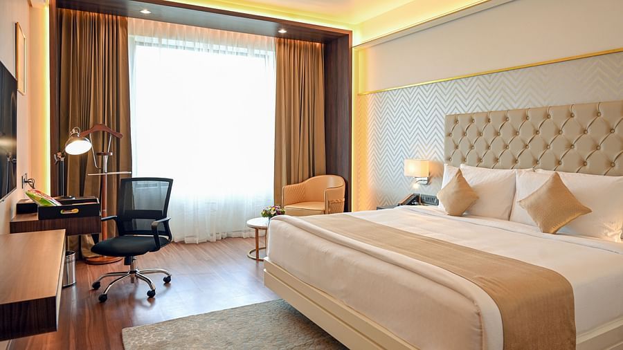 a king size bed and the work station at deluxe rooms in Calicut