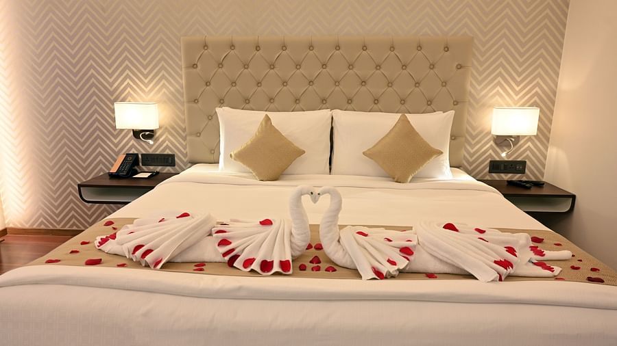 view of the bed with flower petal decorations at the deluxe room in Calicut