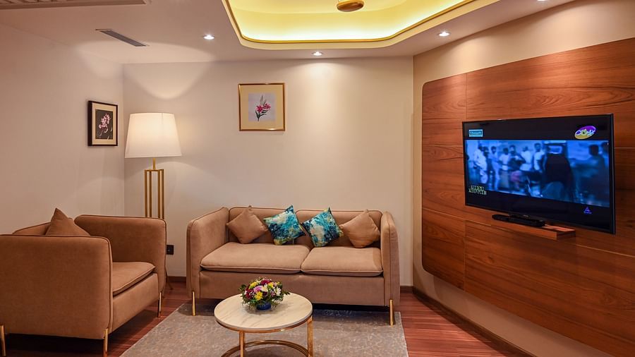 the living space with sofa set and a tv offered by the superior rooms in Kozhikode