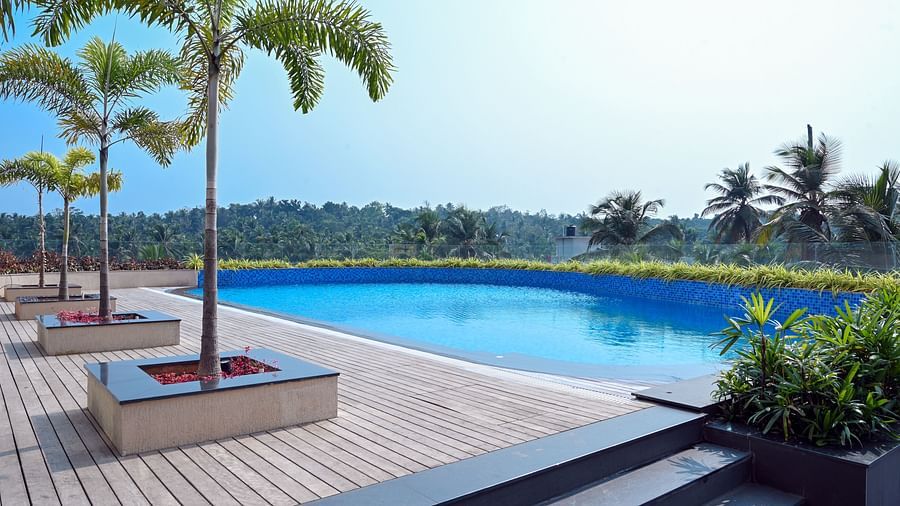 view of the swimming pool of Apollo Dimora hotel in Calicut