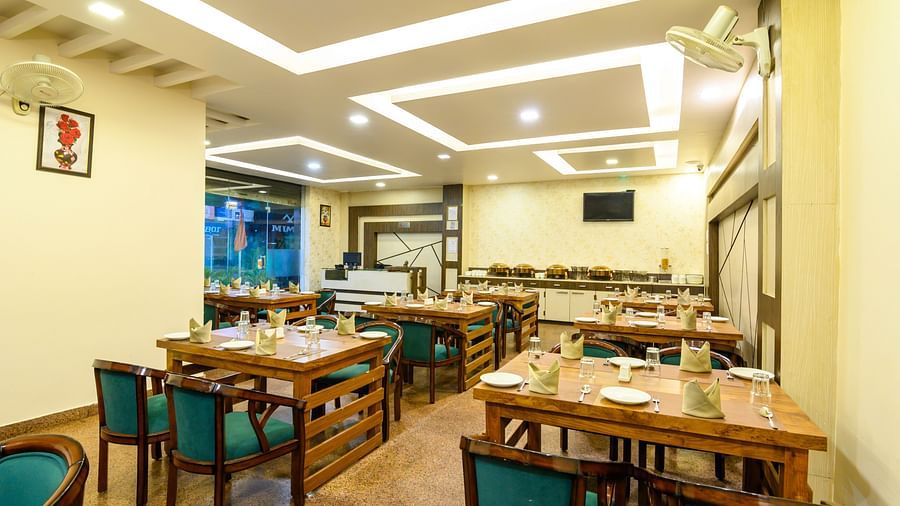 Restaurant featuring stylish interior design and table arrangements at Biznotel by Pride, Deoghar