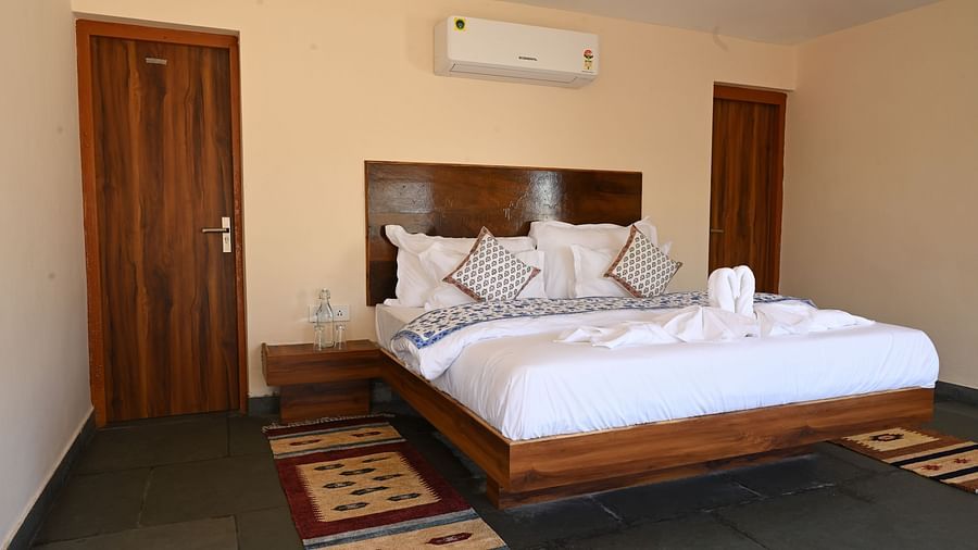 Clarks Safari Jawai - the double bed with white sheets covering it offered by the cottage room in Jawai