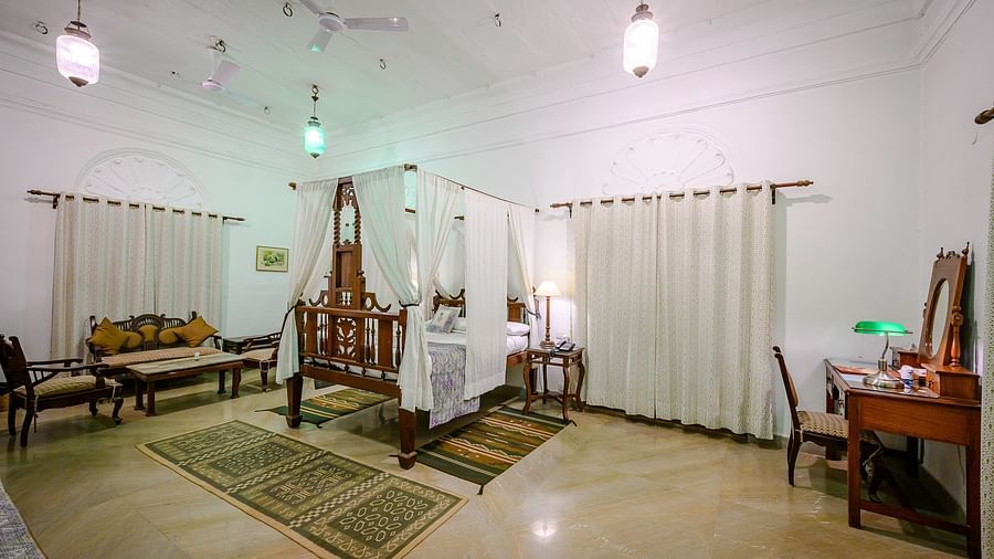 Deo Bagh - 17th Century, Gwalior - the bedroom area along with a sofa set kept on one side of the bed and a dressing table on the other side at the Sakhya Raja Mahal - Naubagh / Garden View