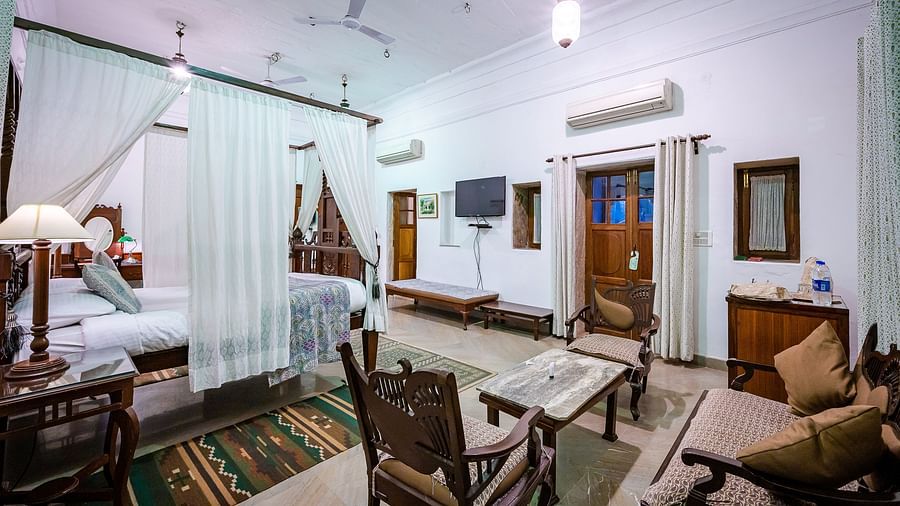 Deo Bagh - 17th Century, Gwalior - the attached seating space with chairs and sofas by the bed offered at Sakhya Raja Mahal - Naubagh / Garden View