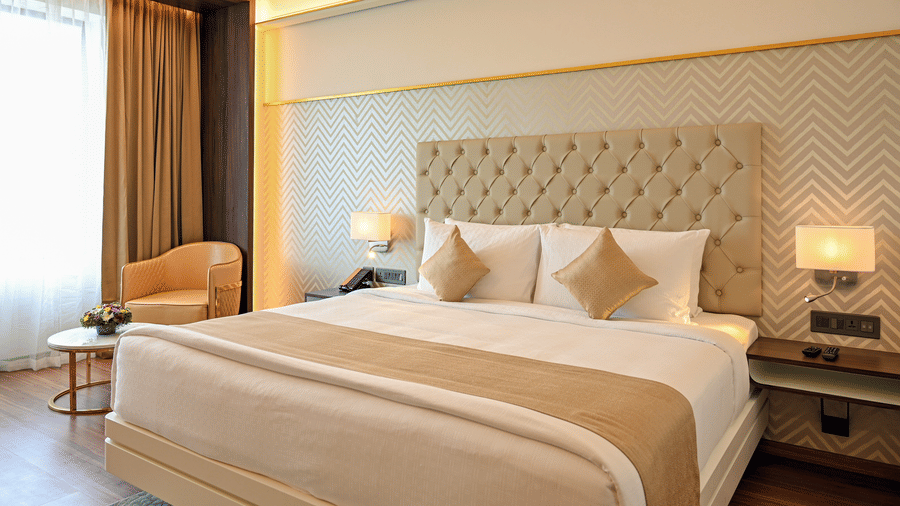 A king size bed and the work station at deluxe rooms in Dimora, Kozhikode.