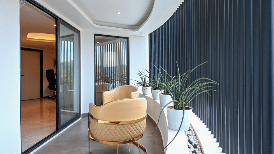 Suite seating nook with elegant gold accent chairs and lush greenery at Dimora Hotels and Resorts, offering a stylish and inviting corner.