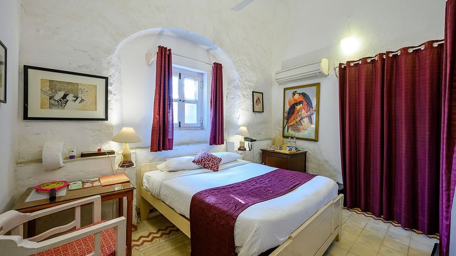 Hill Fort Kesroli 14th Century Alwar - interior view of Baaj Mahal - Garden View with queen size bed and purple curtains