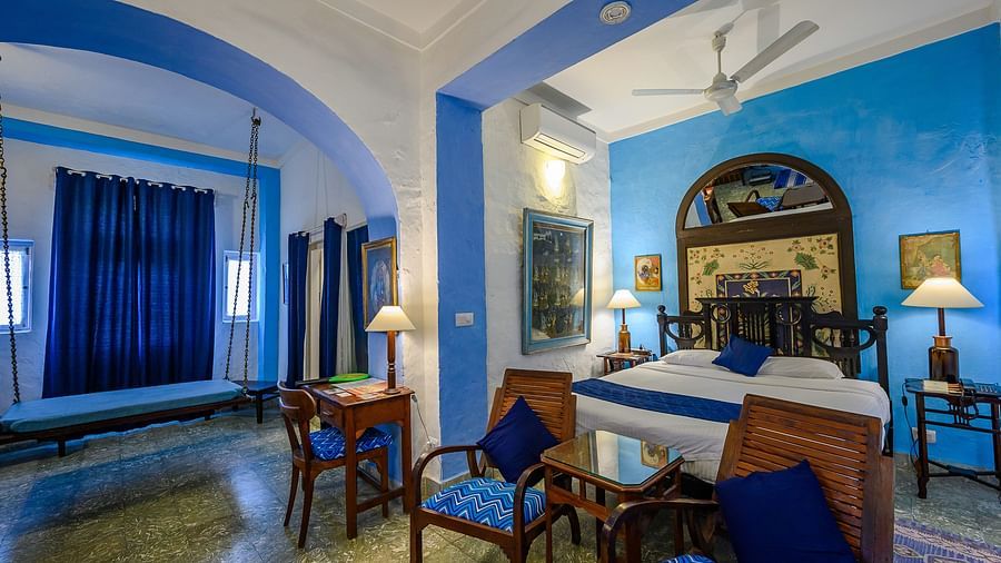 Hill Fort Kesroli 14th Century Alwar - interior view of the Hindola Mahal - Countryside View room with blue decor brown chairs and a bed