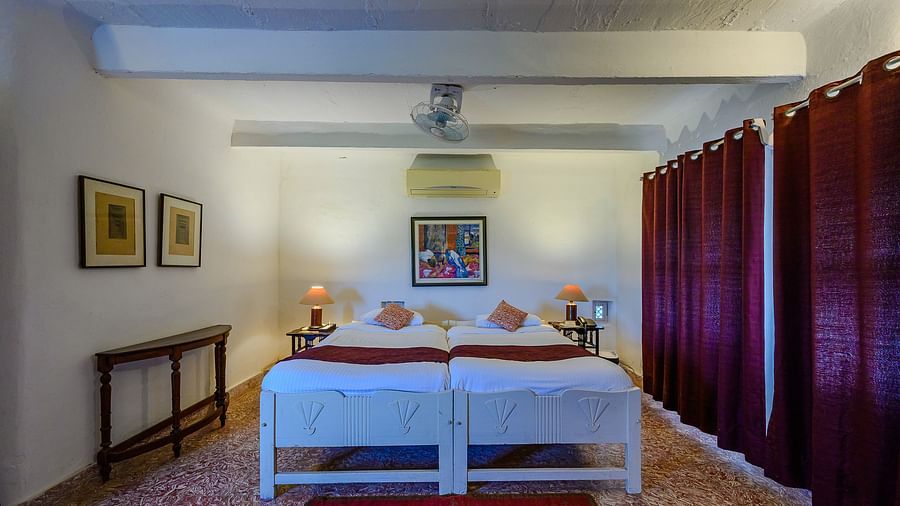 Hill Fort Kesroli 14th Century Alwar - interior view of the Mangal Mahal - Pool View with twin bed and maroon currtains