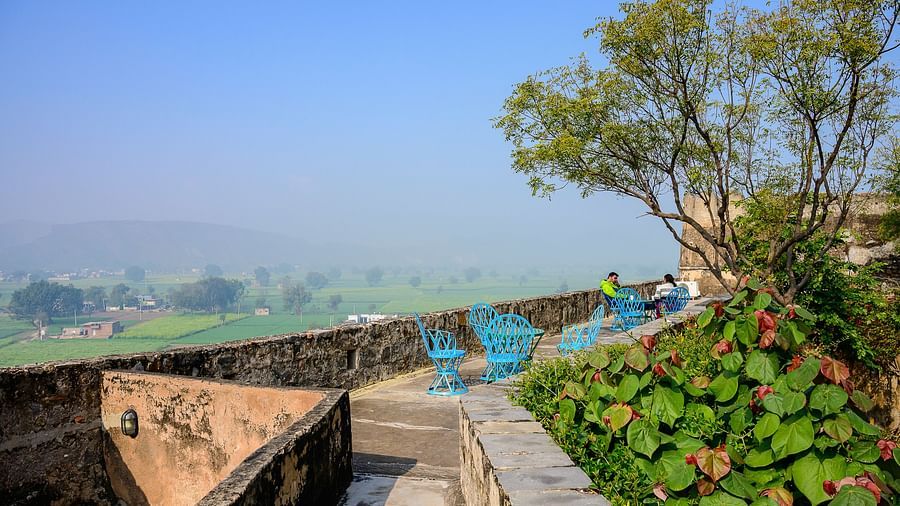 Hill Fort-Kesroli 14th Century Alwar - Image of a small passage at a height containing tables and chairs for people to sit 