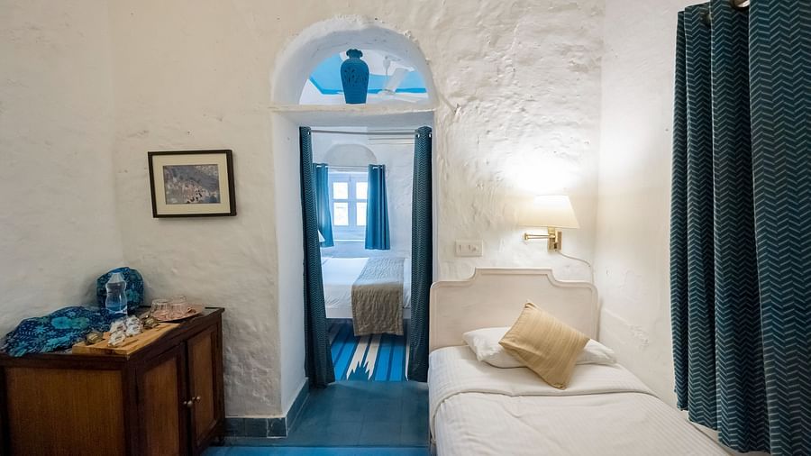 Hill Fort Kesroli 14th Century Alwar - interior view of the Neelkanth Mahal - Countryside View, one of the best hotel rooms in Alwar featuring a single bed and blue curtains