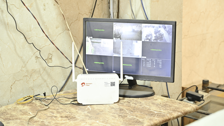 A table with a desktop and a Wi-Fi modem and cables - Hotel Goverdhan, Agra