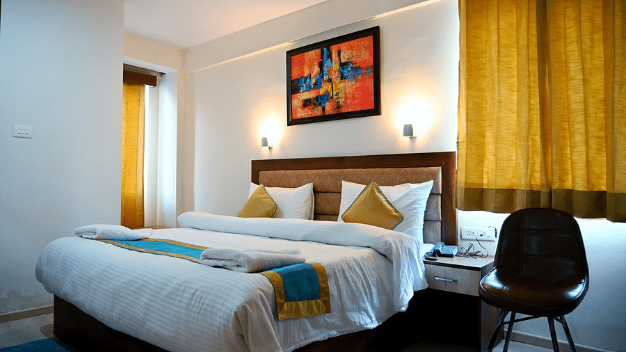 The king size bedding with white sheets in the triple bed room - Panchvati Inn Badrinath