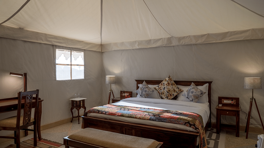 The interiors of the Premium camp offers a comfy bed, work desk and other amenities - Karwaan Jaisalmer
